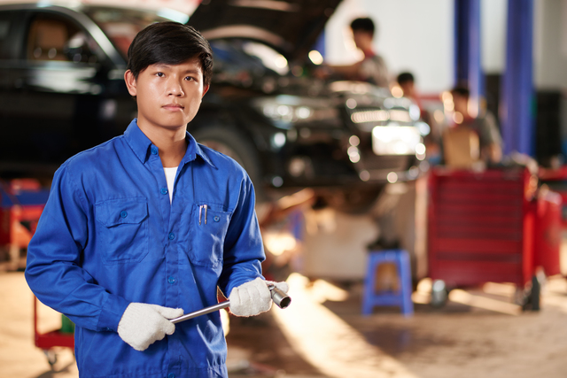 Portrait of young Vietnamese repairman with wrench